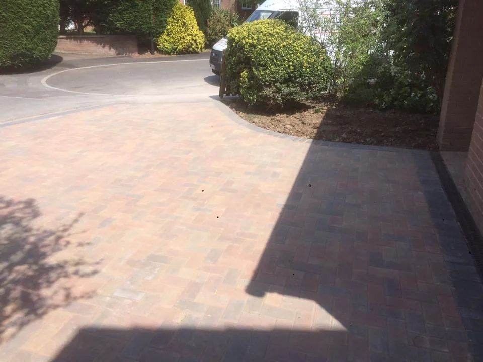 A driveway with a brick walkway between two buildings.
