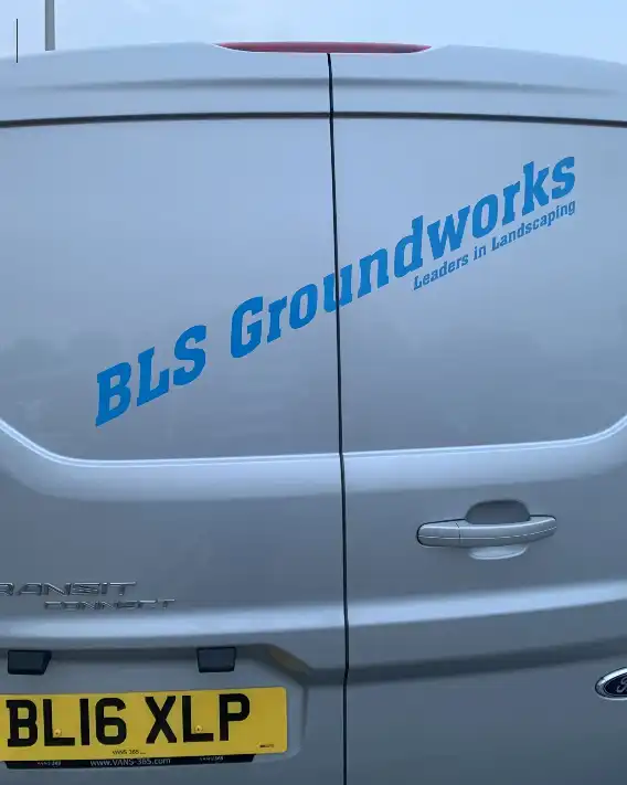 A silver van with a blue logo on it.
